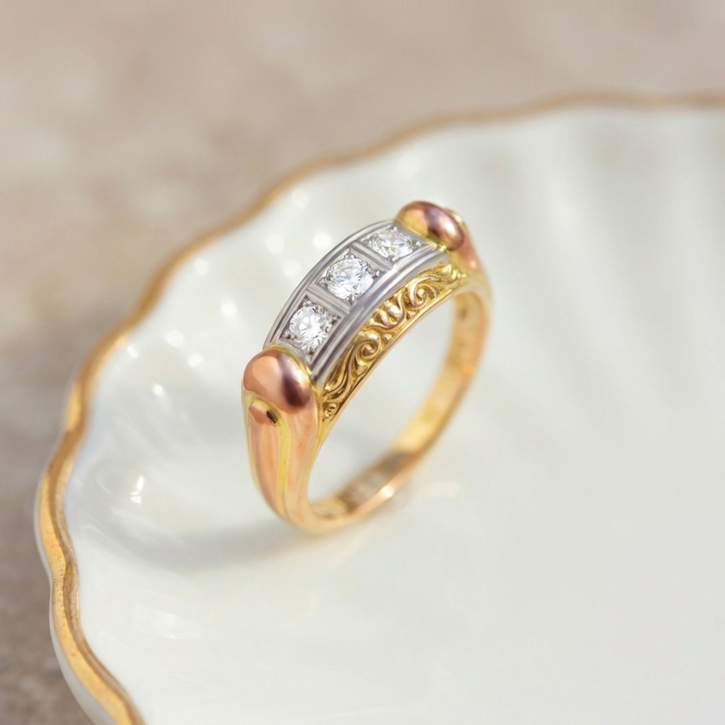 Top-down view of antique tri-color gold ring displaying full length of white gold diamond channel and yellow gold engraving