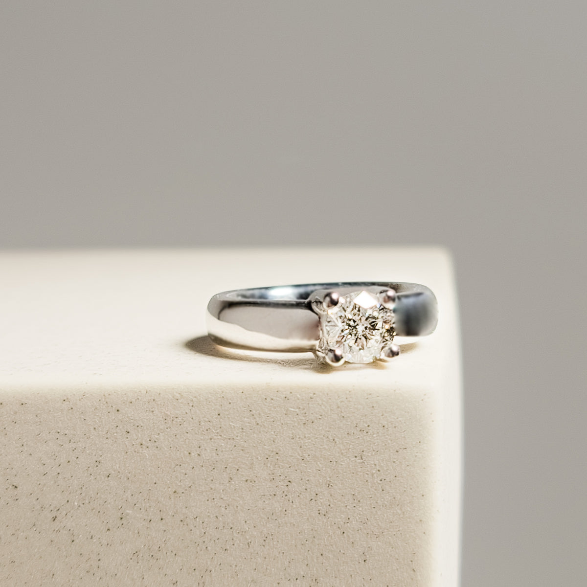 Side profile of 18k white gold solitaire diamond ring showing tapered band and prong setting