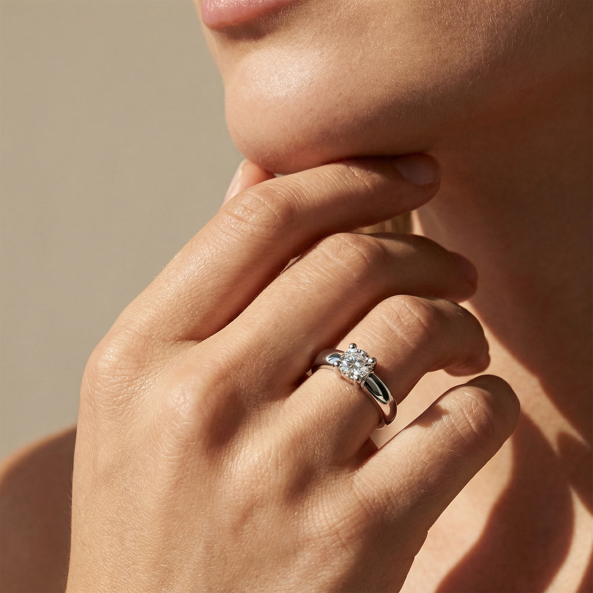 Woman wearing 18k white gold solitaire diamond engagement ring on hand