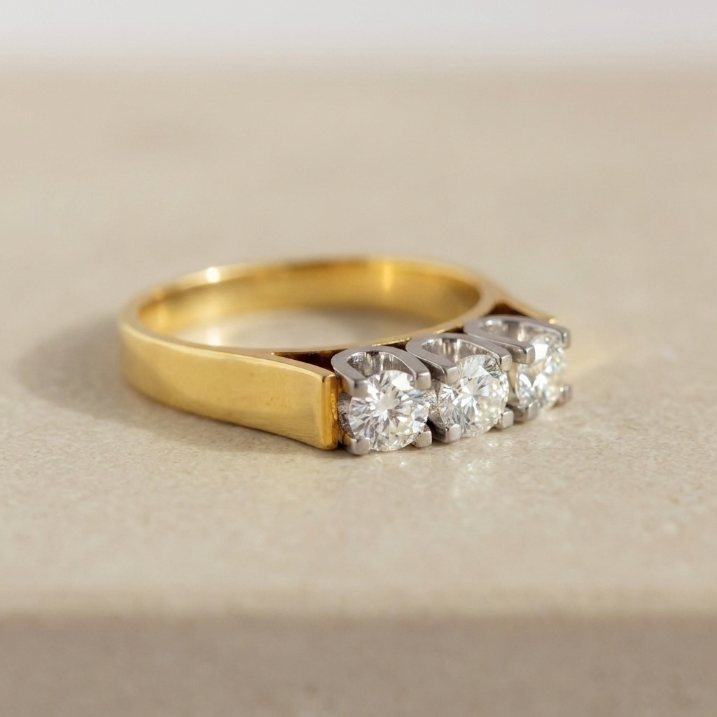 Architectural three-stone diamond ring highlighting wide yellow gold band
