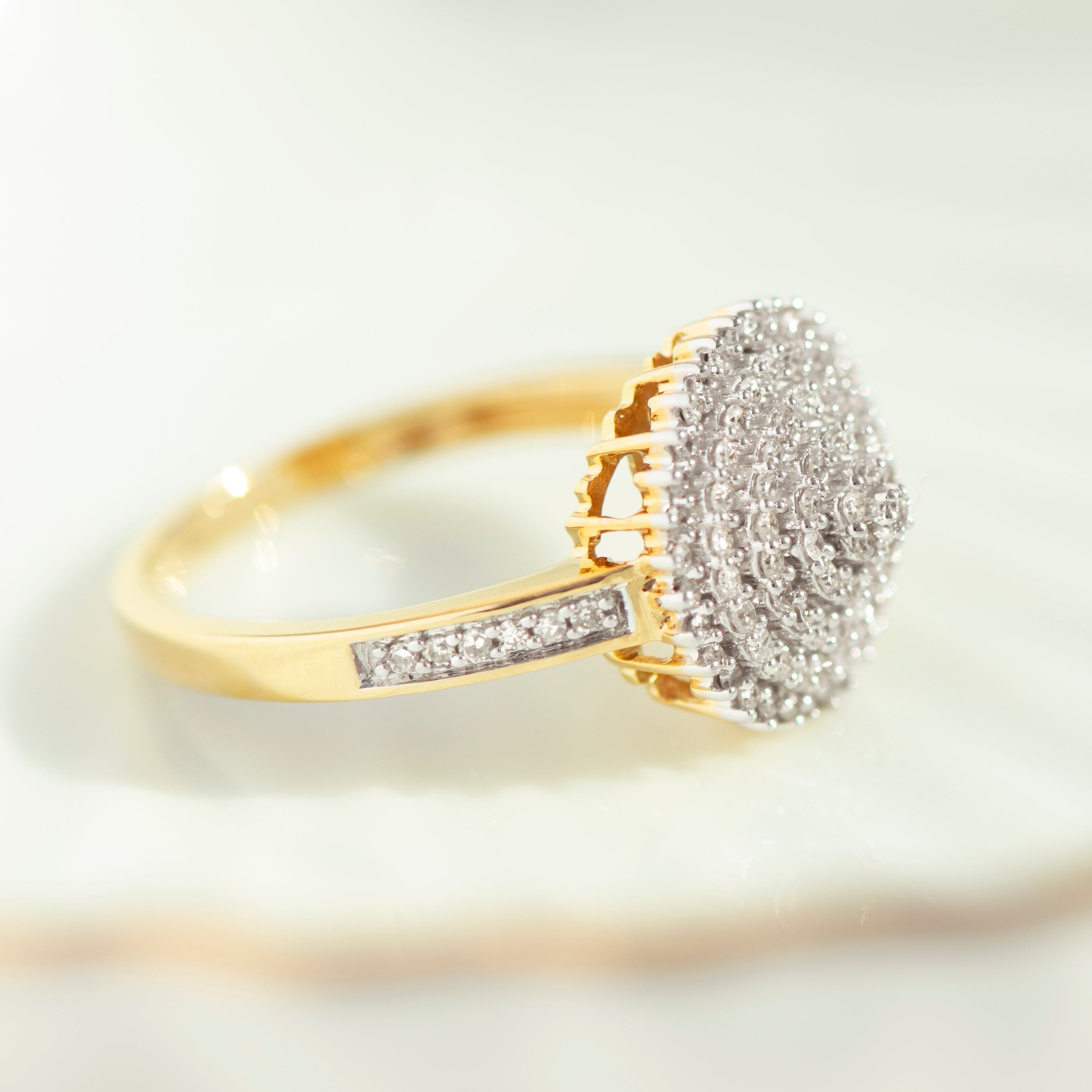 Side profile of vintage style 14k yellow gold diamond snowball ring showing prong setting