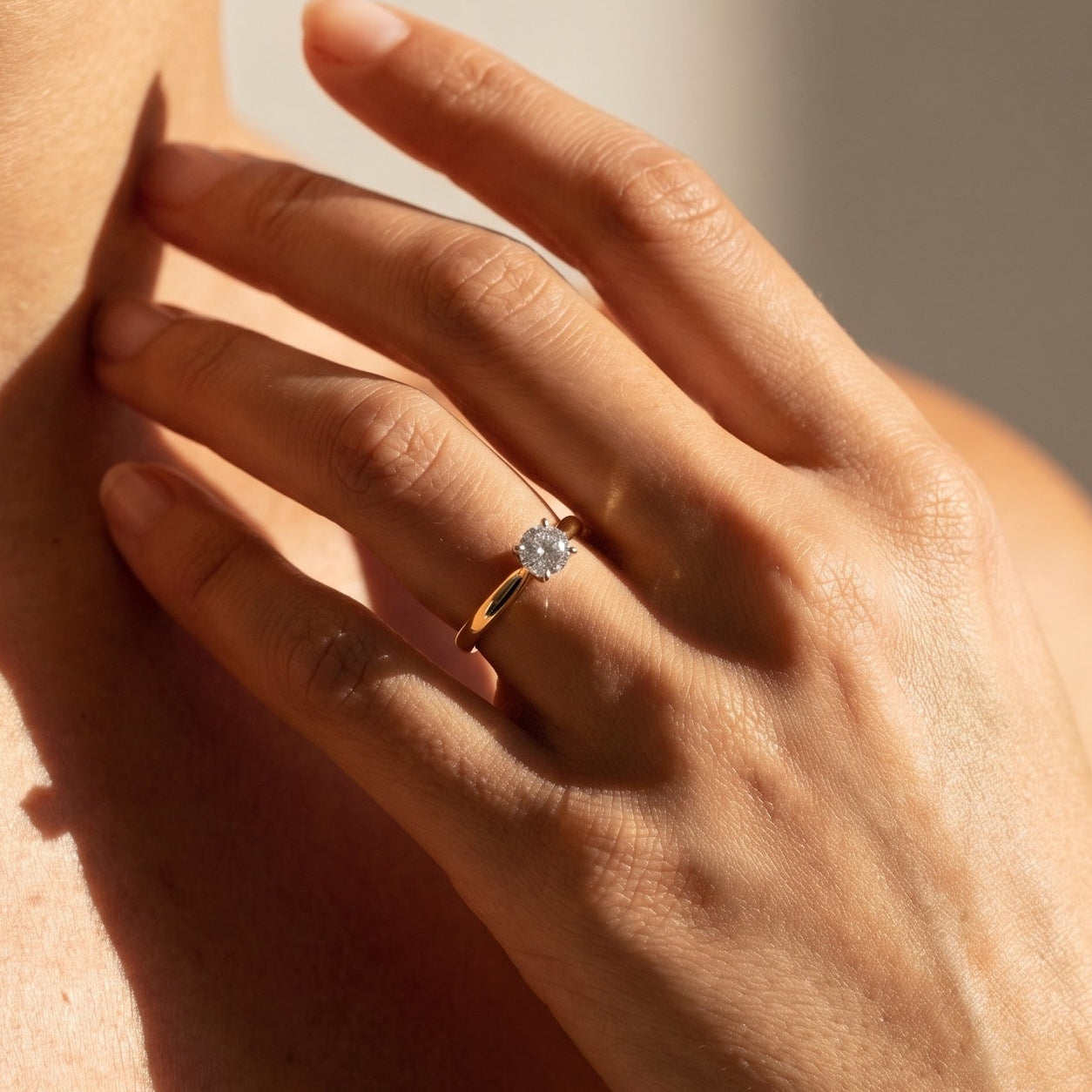 Woman wearing 14k yellow gold and white gold solitaire diamond ring on hand