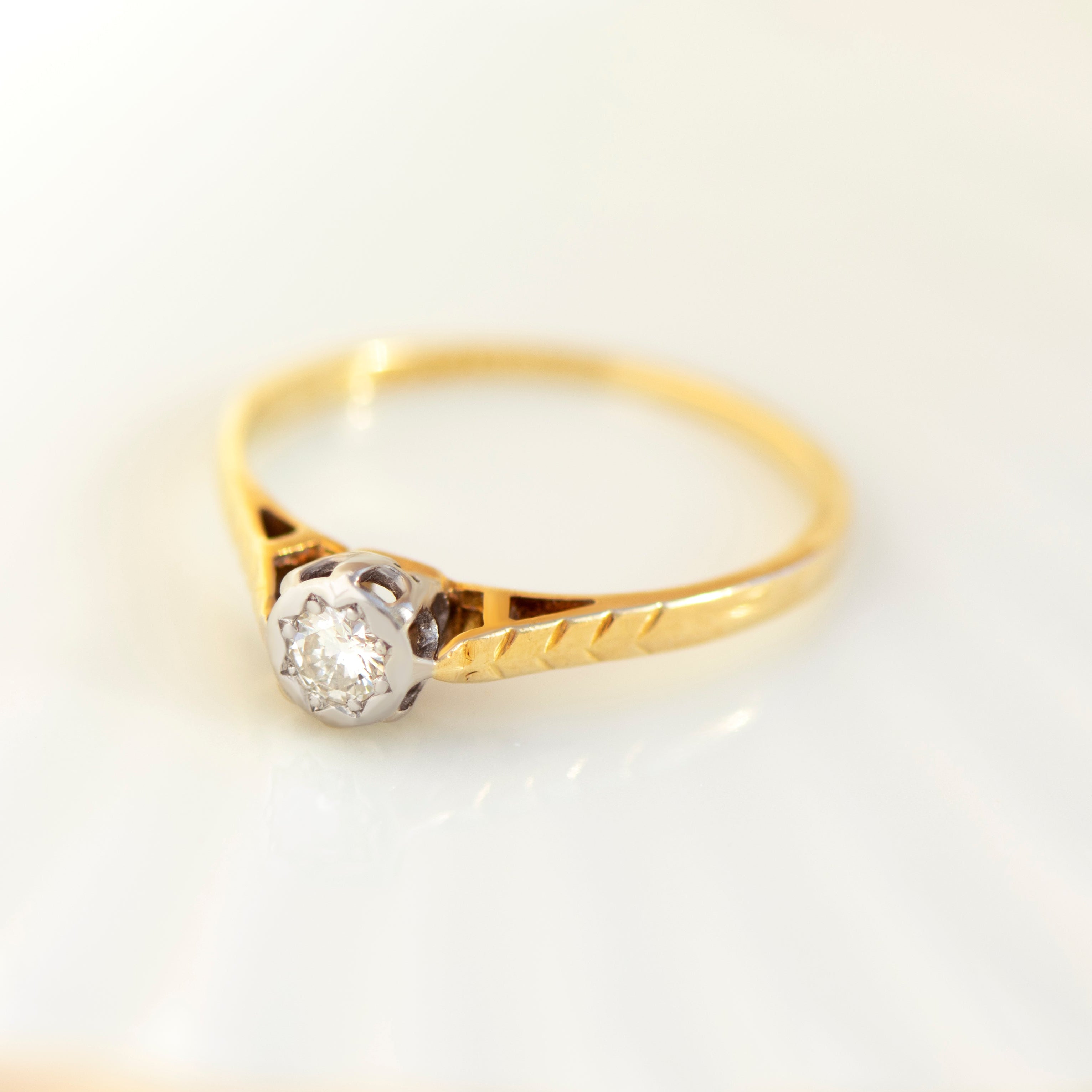 Vintage 18k yellow gold solitaire diamond ring with white gold setting and engraved shoulders