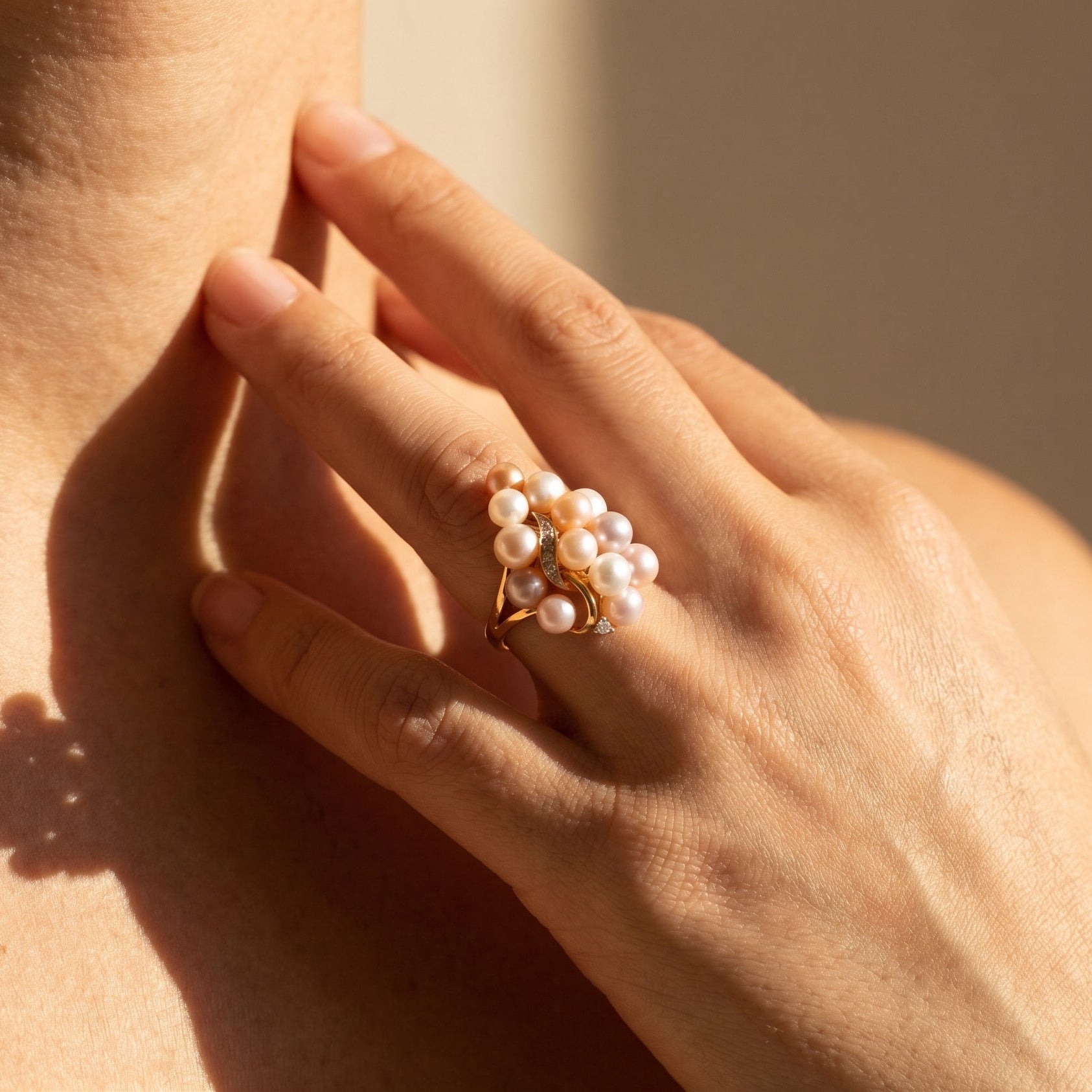 Three-dimensional 14k gold grape ring worn on hand showing pearl luster and diamond shine