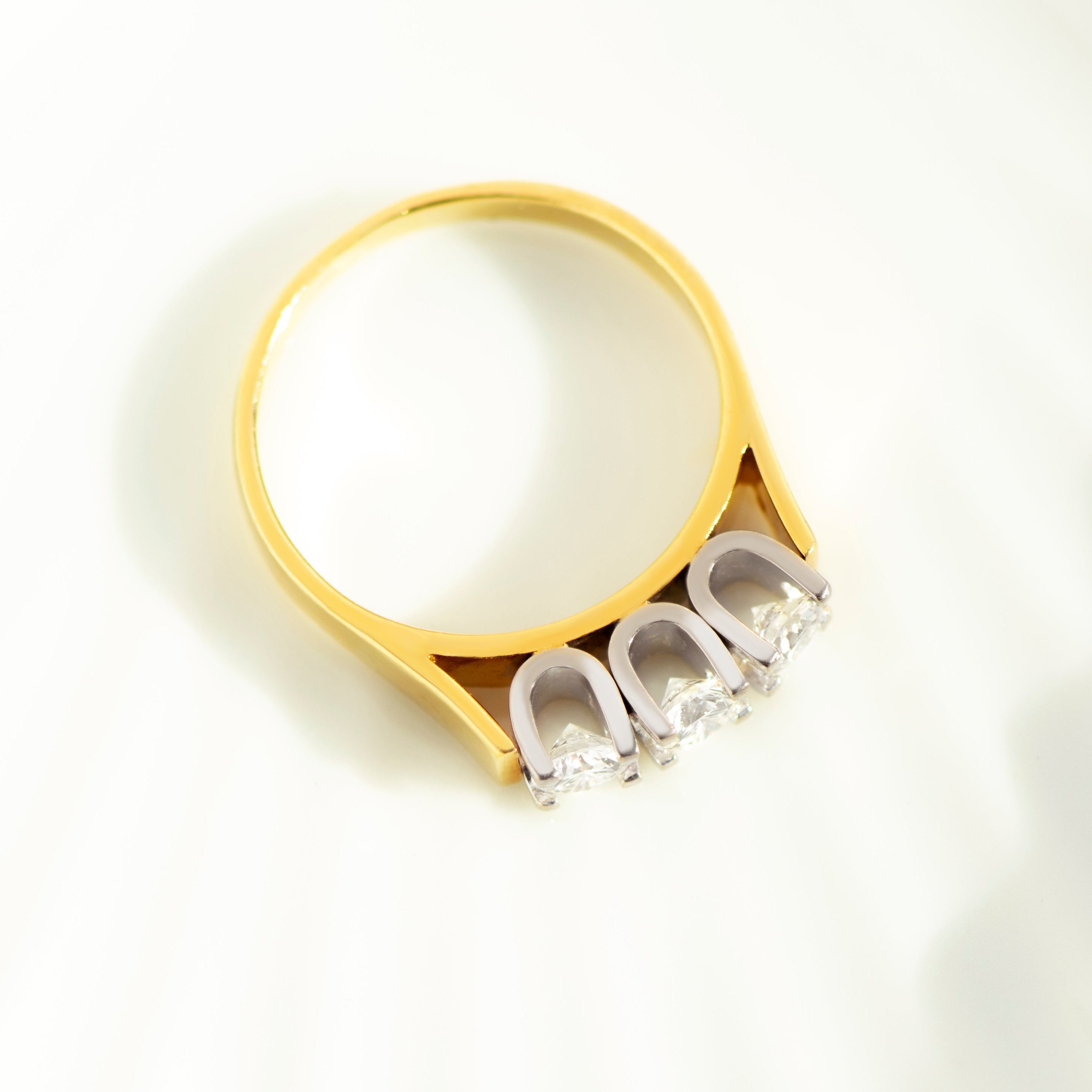 Overhead view of geometric three-stone diamond ring in two-tone gold
