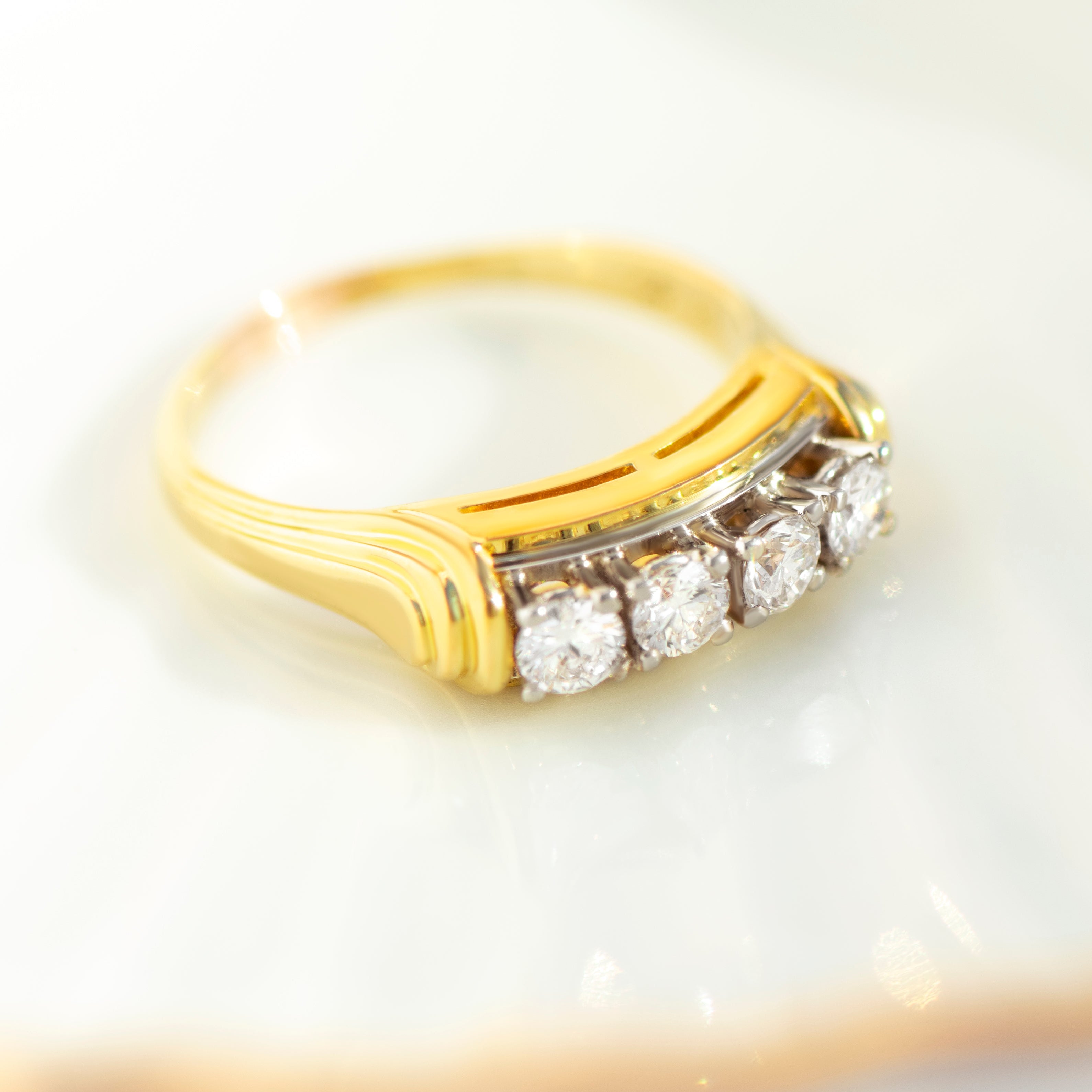Diagonal view of vintage 18k yellow gold diamond ring with openwork band